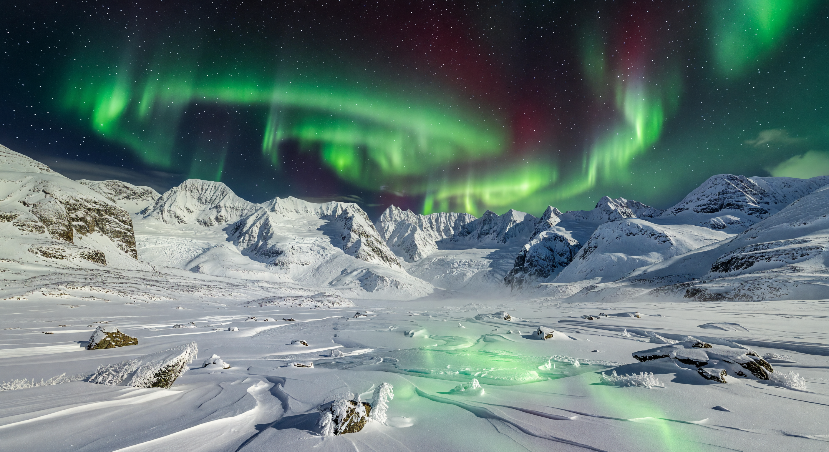 Aurora Borealis over Snow-Covered Mountains